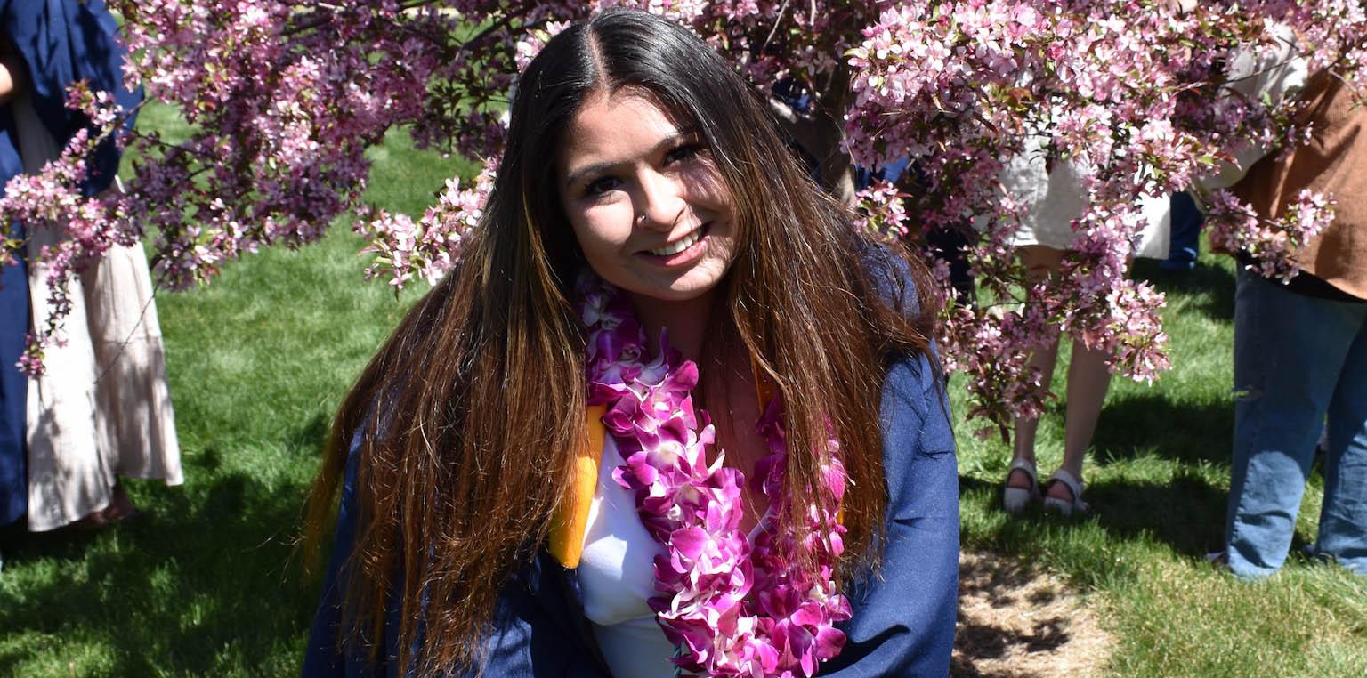 Michelle Sarahang smiles wearing her graduation regalia.